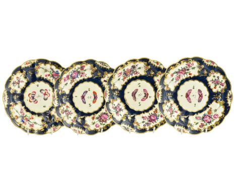 A Set of Four Worcester Porcelain Soup Plates, circa 1775, painted with flowers in panels on a blue scale ground, fret marks 