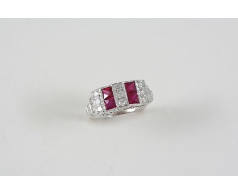 A RUBY AND DIAMOND RING set with four square-shaped rubies and with circular-cut diamonds, in 18ct. white gold. Size O.