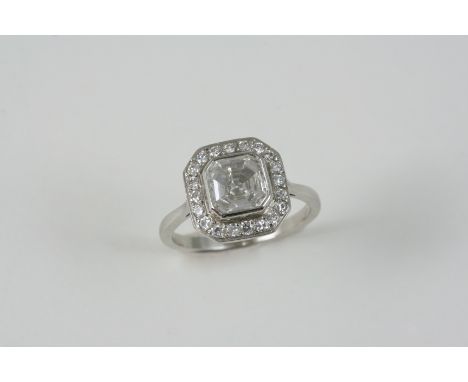 AN EARLY 20TH CENTURY DIAMOND CLUSTER RING centred with an octagonal shaped diamond weighing approximately 1.14 carats in rub