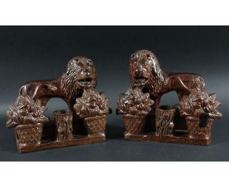 PAIR OF SALT GLAZED STONEWARE LION SPILL VASES, mid 19th century, modelled standing facing left and right behind baskets of f