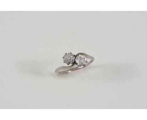 A DIAMOND TWO STONE CROSS-OVER RING set with two old brilliant-cut diamonds. Size N.