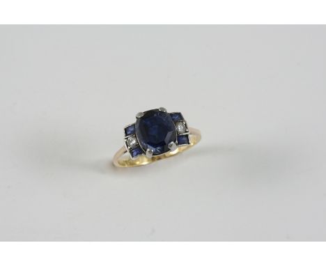 A SAPPHIRE AND DIAMOND RING the oval-shaped sapphire is set with two rectangular-shaped sapphires and a circular-cut diamond,