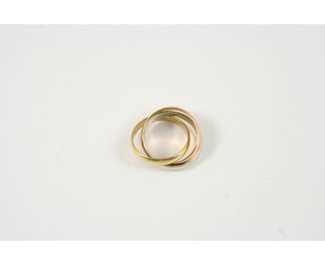 AN 18CT. THREE COLOUR GOLD RING BY MUST DE CARTIER formed as three interlocking gold bands, signed to the outside of one of t