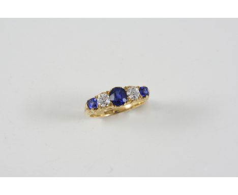 A SAPPHIRE AND DIAMOND FIVE STONE RING the three graduated sapphires are set with two circular-cut diamonds, in 18ct. gold ca