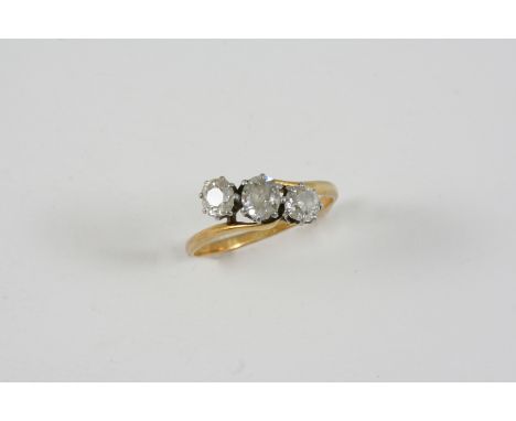 A DIAMOND THREE STONE RING set with three old brilliant-cut diamonds in 18ct. gold and platinum. Size R.