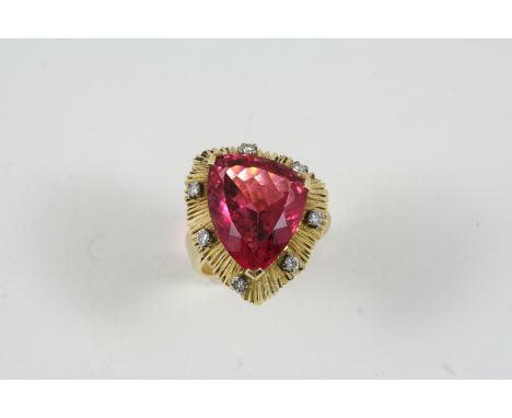 A TOURMALINE AND DIAMOND COCKTAIL RING the pink tourmaline is set within an abstract design gold surround mounted with small 