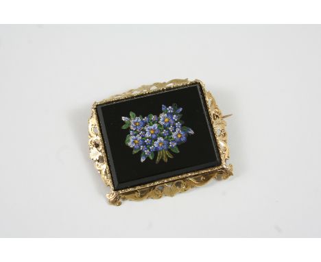 A MICROMOSAIC BROOCH depicting a bunch of flowers on a black enamel ground, in a gold foliate frame, 5cm. wide.
