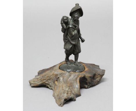 JAPANESE BRONZE OKIMONO, modelled as a man with a monkey on his back, mounted on a root wood base, height including base 31cm