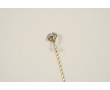 A DIAMOND STICK PIN in the form of a question mark, millegrain set with circular-cut diamonds, in gold. With box.