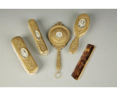 A FRENCH GILT METAL FIVE PIECE DRESSING TABLE SET comprising brushes, mirror and comb mounted with miniature portraits, late 