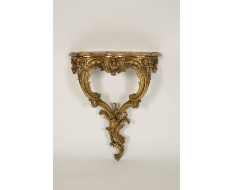 A LOUIS XV GILTWOOD CONSOLE TABLE, the serpentine fronted marble top with a moulded border on a rococo style carved frieze an