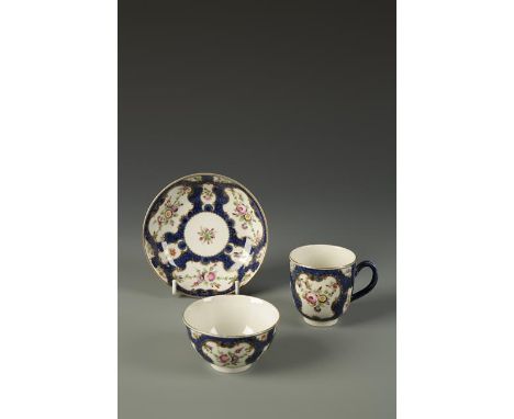 A WORCESTER TEA CUP, COFFEE CUP AND SAUCER painted in coloured enamels with flowers and leaves, within gilt cartouches, on bl