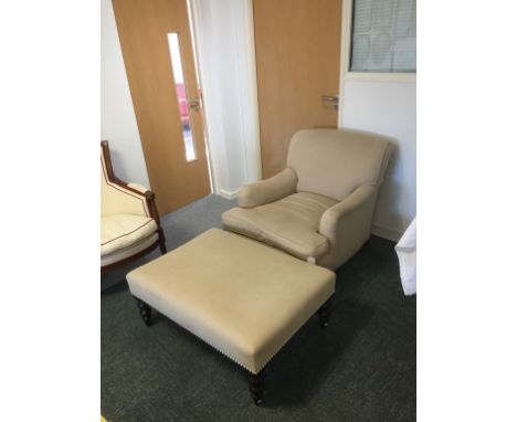 A VICTORIAN STYLE ARMCHAIR with deep seat upholstered in beige, on short turned front legs and brass castors, 33" high, and a