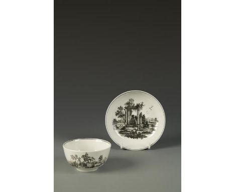 A WORCESTER PORCELAIN LARGE TEA BOW AND SAUCER printed in black with ruins, within black line borders, c. 1770