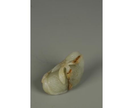 A CHINESE CELADON JADE CRANE PENDANT, the bird with its head turned backwards and holding foliage, Qing, 17th/18th century, 2