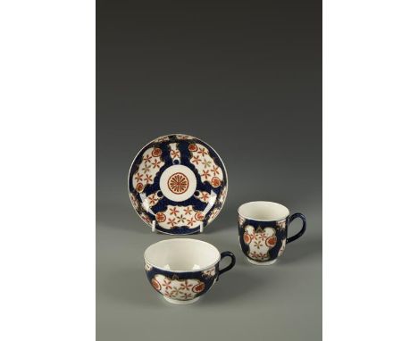 A WORCESTER TEA CUP, COFFEE CUP AND SAUCER decorated in the Japanese style with painted iron red flowerheads within gilt cart