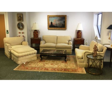 A FOUR PIECE LOUNGE SUITE upholstered in woven cream fabric. Comprising a settee, two armchairs and a pouffe, with bound bord