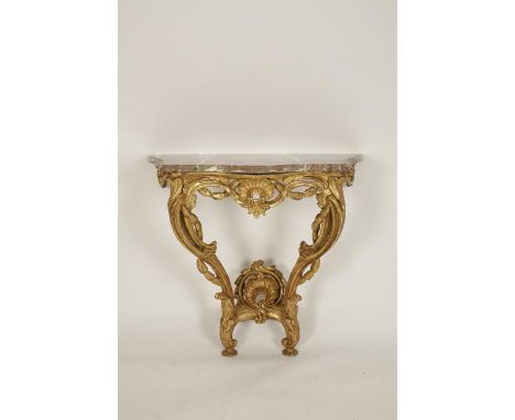 A LOUIS XV CARVED GILTWOOD AND MARBLE TOPPED CONSOLE TABLE, the serpentine fronted top on twin pierced and leaf carved cabrio