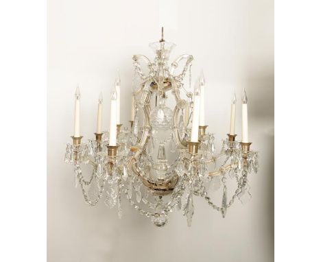 A CONTINENTAL CHANDELIER with twelve scrolling branches emanating from a central cartouche shaped frame with a dimpled ball h