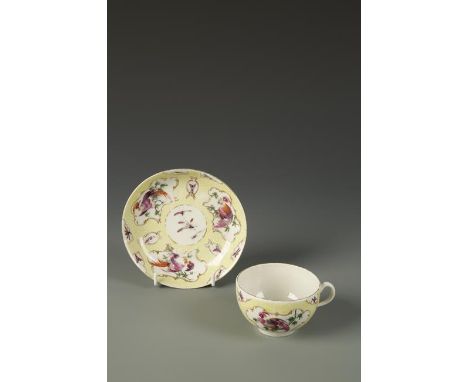 A WORCESTER TEA CUP AND SAUCER painted in coloured enamels with exotic birds and insects, within gilt cartouches, on yellow s