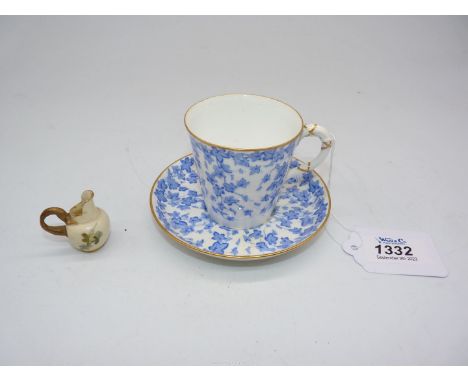 A Royal Worcester cup and saucer in blue ivy leaf pattern on cream ground and a miniature Royal Worcester porcelain jug paint