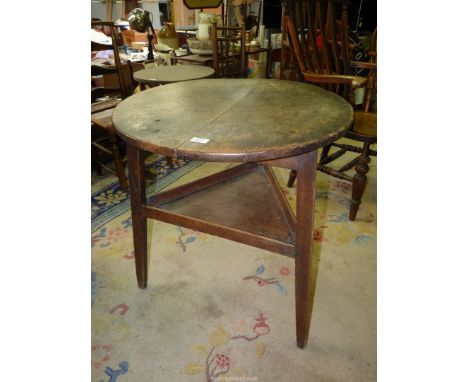 A period Cricket Table of principally Elm construction, the legs united by a triangular lower shelf, 27 3/4'' diameter, 29 1/