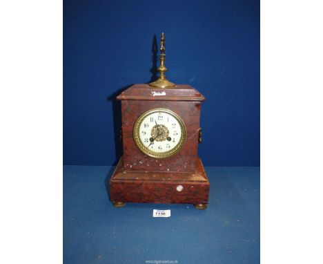 A two train movement French red marble mantle Clock with Arabic numerals having carrying handles to the side and a metal fini