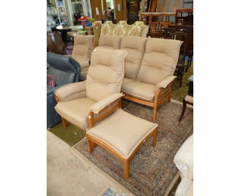 An "Ercol" elm framed Lounge Suite comprising a pair of armchairs, three seater settee and a footstool, all having beige upho