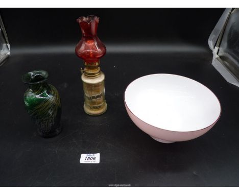 Three pieces of glass including pink bowl with white interior, green bud vase with gold swirls and small oil lamp with sand a