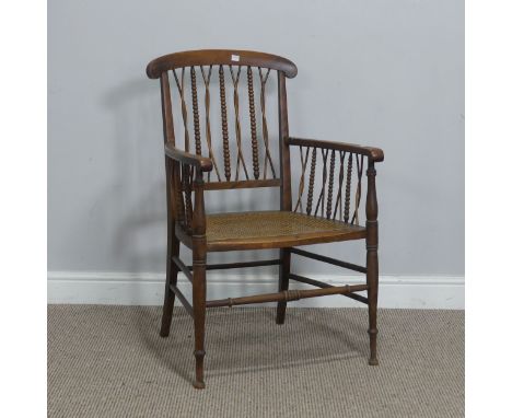 An early 20th century Armchair, with bobbin and weaved spindle back, over caned seat and turned supports, W 52 cm x H 84.5 cm