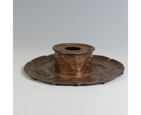 An Arts and Crafts Cornish copper Inkwell, in the manner of Newlyn, the circular dish repousse decorated with fish and seawee