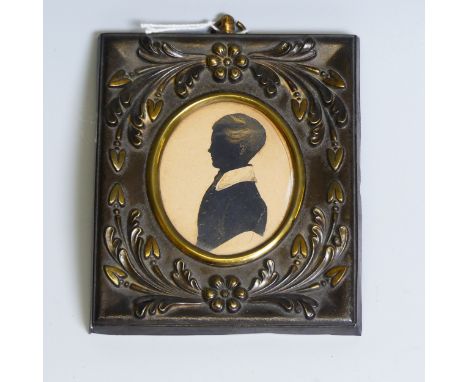 An oval silhouette of a young man, 19th century, heightened with gilt, mounted in an embossed metal frame, overall 12cm x 10c
