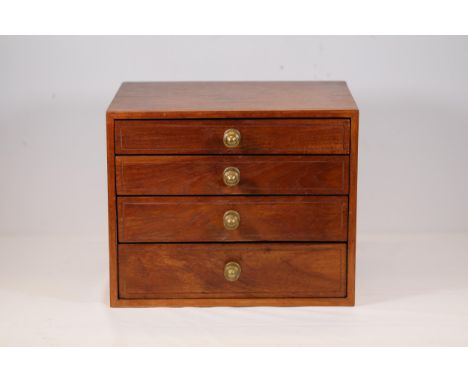**Small Wooden Chest of Drawers with Brass Handles**  This finely crafted wooden chest of drawers features four spacious draw