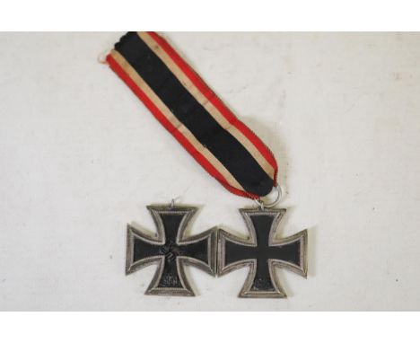 **World War II German Iron Cross Medals with Striped Ribbons**  This collection includes two historically significant German 
