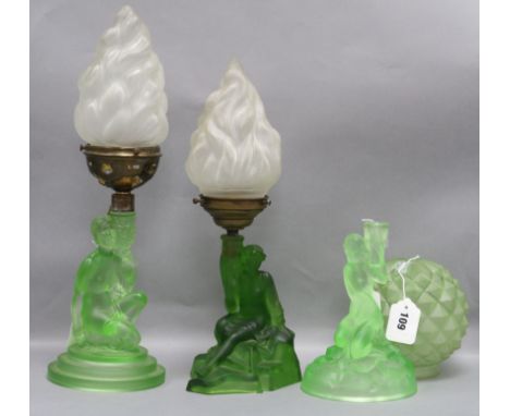 A frosted green glass figural lamp base, possibly by Schweig, Muller & Co, two similar lamp bases and three shades, the bases
