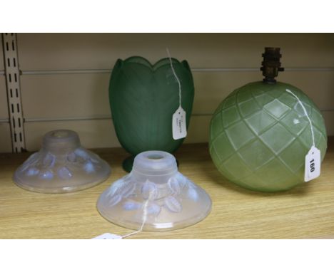 A pair of rose-moulded frosted glass lamp shades and two green glass table lamps, one example of globular form with lattice m