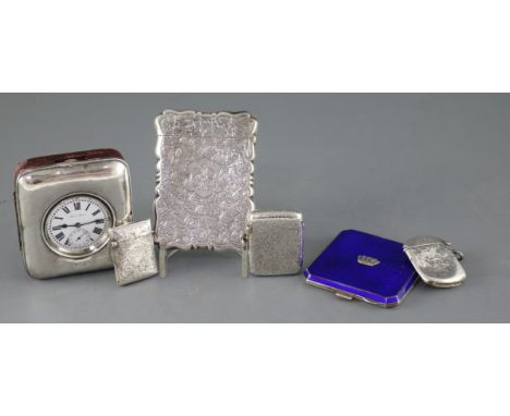 A George V silver mounted travelling timepiece, fitted with a base metal pocket watch, an Edwardian silver card case, three v