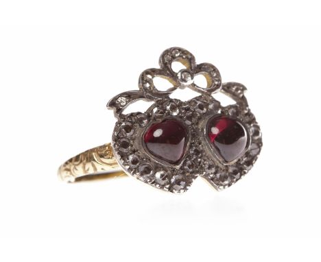GARNET AND DIAMOND RINGwith two heart shaped cabochon cut garnets surrounded by old cut diamonds and topped by a diamond set 
