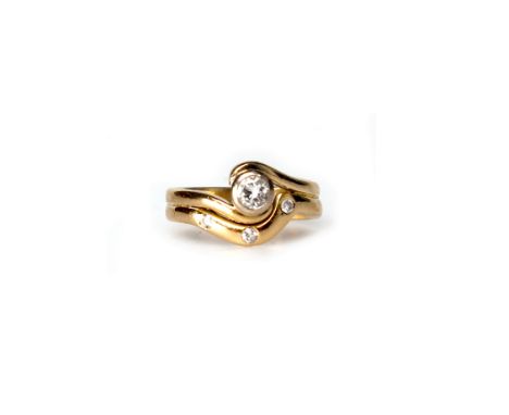 DIAMOND DRESS RINGthe central round brilliant cut diamond of approximately 0.18 carats, in a twist setting with attached band