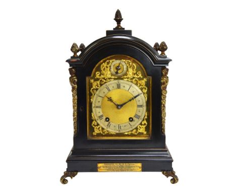 A German eight day ebonised mantel clock, late 19th century, the arch top case with foliate finials, the dial plate with subs