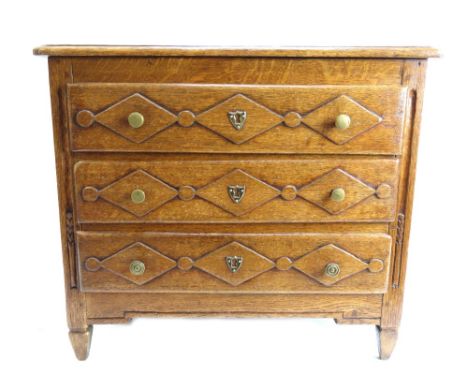A small provincial French oak commode of 18th century design, with three long diamond moulded drawers, on tapering square sup