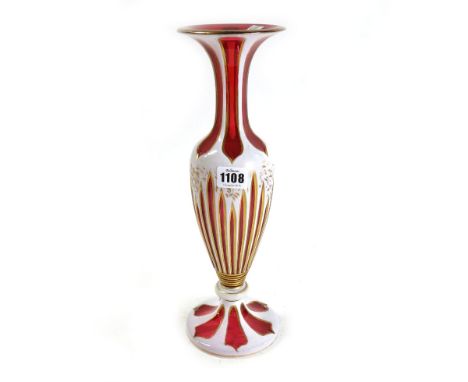 A cranberry and white enamel glass vase, late 19th/early 20th century, with gilt foliate decoration against a baluster body, 