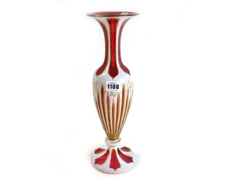 A cranberry and white enamel glass vase, late 19th/early 20th century, with gilt foliate decoration against a baluster body, 