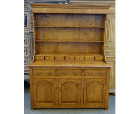 An 18th century style oak dresser, the enclosed three tier plate rack with seven spice drawers over three lower drawers and c