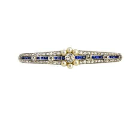 A diamond, sapphire and seed pearl brooch, in a tapered elliptical design, centred by the principal cushion shaped diamond, i