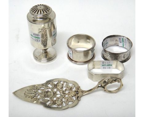 A George III silver pepperette, of cylindrical form, London 1811, three silver napkin rings and a foreign serving trowel, wit