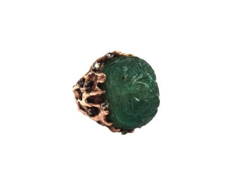 A gold, carved emerald and diamond ring, the carved emerald having foliate decoration, possibly Indian, the mount in a cast a