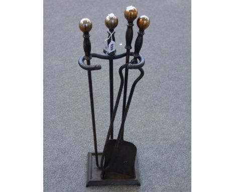 A set of ebonised steel fire tools and stand with spherical brass finials (shovel 70cm), a pair of patinated metal 'Owl' andi