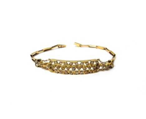A gold and diamond set bracelet, the front in a curved panel shaped pierced geometric design, mounted with cushion shaped dia
