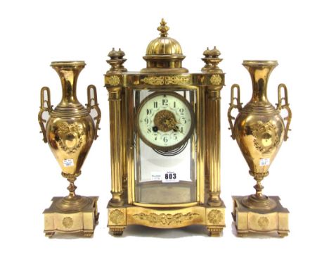 A French gilt brass four-glass mantel clock garniture, late 19th/early 20th century, with dome surmount and four pillared cas